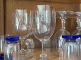 several empty wine glasses are sitting on a shelf in a kitchen