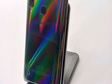 a close up of a cell phone on a stand with a rainbow background