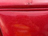 a close up of a red toilet in a public restroom