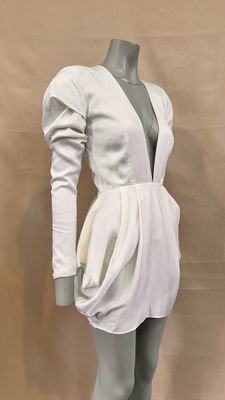 the mannequin is wearing a white dress with long sleeves