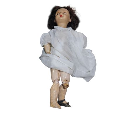 an old doll with a white dress and black shoes on a white background