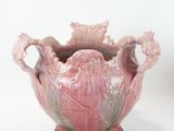 a pink vase that is sitting on a white surface