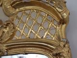 a mirror with a gold frame on the wall