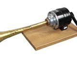 a brass trumpet on a wooden stand with a black horn