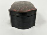 a small black box with a red design on the lid