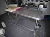 une cuisine équipée d'une table en acier inoxydable