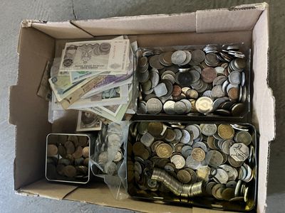 une boîte remplie de pièces et de billets posée par terre
