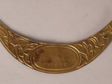 a close up of a brass plate on a white surface