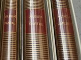 three books are in a box on a table