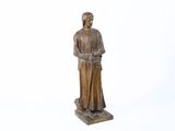 statue d'une femme portant un chapeau et une canne, sur fond blanc