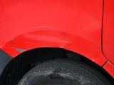 a close up of a red car with a flat tire
