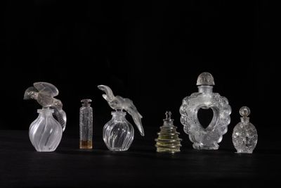 several glass bottles with birds on them sitting on a table