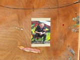 a picture of a man sitting on a chair in front of a refrigerator