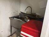 une cuisine sale avec un évier et une cuisinière