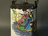 a small container with a handle that has a painting on it