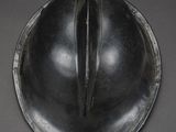 an old helmet is sitting on a table with a black background