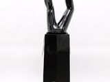 sculpture of a pair of black legs sticking out of a black vase