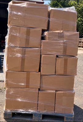 a large stack of boxes sitting on a pallet in the parking lot