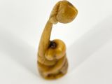 a small wooden elephant figurine on a white surface