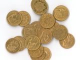 some gold coins on a white surface with a white background