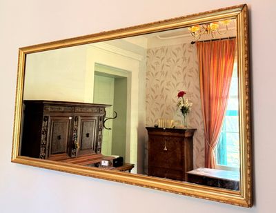 a large mirror hanging on the wall above a dresser