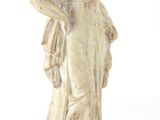 statue d'une femme en robe blanche posée sur un socle en bois