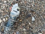 a broken drill on the ground next to some rocks