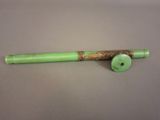 a close up of a green pipe with a wooden handle
