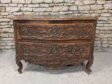 une vieille commode en bois ornée de sculptures élaborées sur le dessus