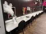 une longue table sur laquelle se trouve un vase de fleurs, dans une pièce