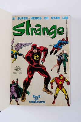 La couverture d'une bande dessinée est ouverte sur une surface blanche.
