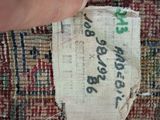 someone is stitching a piece of fabric on top of a rug