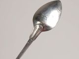 a silver spoon with a silver handle on a white surface