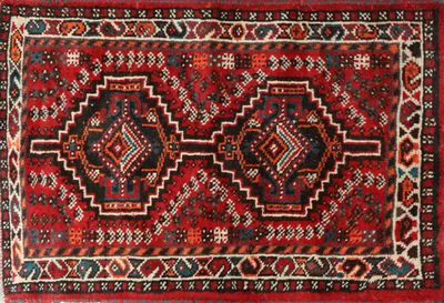 un gros plan sur un tapis rouge orné de deux médaillons