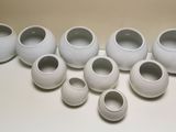 nine white vases sitting on a table with a mouse nearby