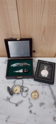 une boîte contenant une montre de poche et d'autres objets, posée sur une table