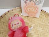 a pink stuffed animal sitting on a table next to a box