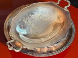 a silver plate on a red table with a hat on it