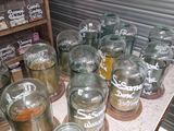 de nombreux bocaux en verre posés sur une table dans une pièce