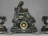une statue représentant une femme assise sur une table, à côté de trois vases