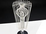 a wire sculpture of a person standing on a table