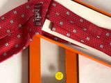 an orange box with a tie in it sitting on top of a white table