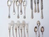 a lot of silver spoons and spoons on the table