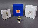 a small figurine of a man with a hat and vest