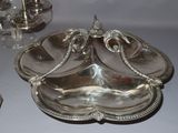 a silver plate with a bird on it sitting on a table