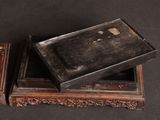 pair of antique wooden boxes sitting on top of a black table