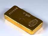 un lingot d'or posé sur une surface blanche