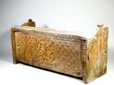 a wooden box with carvings on it on a white surface