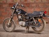 a black motorcycle parked in front of a brick wall
