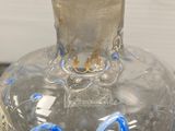 a clear glass bottle with a blue design on it